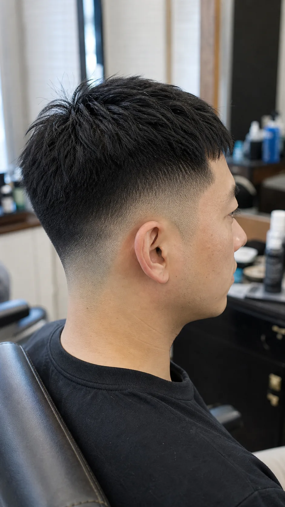 Straight hair low skin fade textured crop with the fade visible around the ear